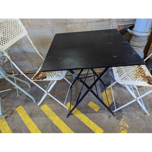 1010 - A square metal folding bistro table, width 60cm, height 71cm, together with two metal chairs... 