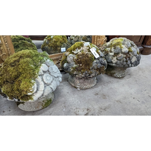 1015 - A set of three weathered reconstituted stone garden ornaments modelled as floral bunches, diameter 3... 