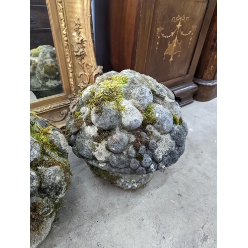 1015 - A set of three weathered reconstituted stone garden ornaments modelled as floral bunches, diameter 3... 