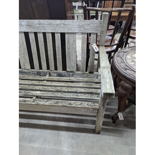 1054 - A weathered teak garden bench, length 158cm, depth 62cm, height 84cm