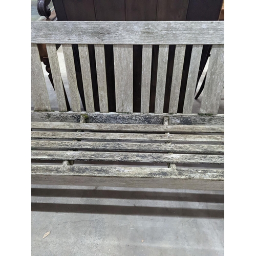 1054 - A weathered teak garden bench, length 158cm, depth 62cm, height 84cm