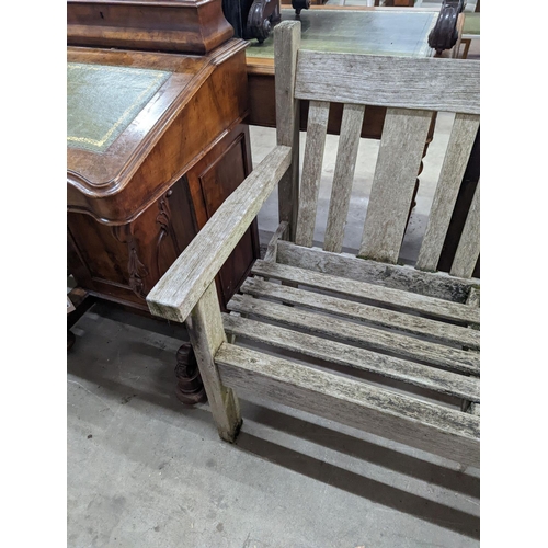 1054 - A weathered teak garden bench, length 158cm, depth 62cm, height 84cm