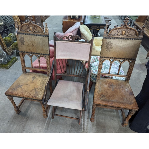 1059 - A pair of Gothic style carved walnut and leather side chairs together with an Edwardian beech foldin... 