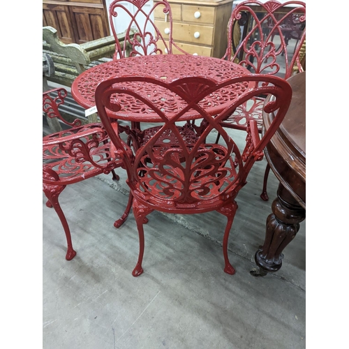 1070 - A circular red painted aluminium garden table, diameter 86cm, height 67cm together with four matchin... 