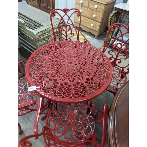 1070 - A circular red painted aluminium garden table, diameter 86cm, height 67cm together with four matchin... 