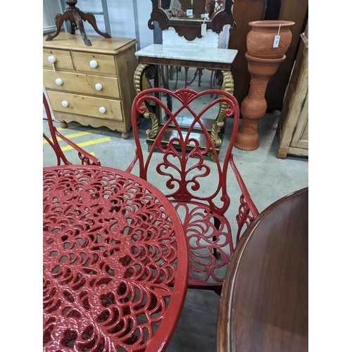 1070 - A circular red painted aluminium garden table, diameter 86cm, height 67cm together with four matchin... 