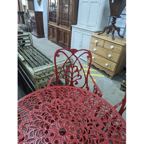 1070 - A circular red painted aluminium garden table, diameter 86cm, height 67cm together with four matchin... 