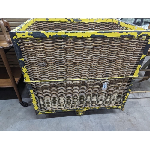 1096 - A vintage wicker and iron laundry basket on wheels, width 85cm, depth 61cm, height 87cm