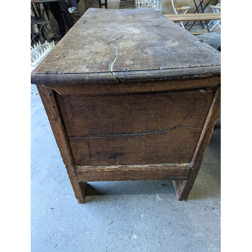 1111 - A large 17th century oak panelled coffer, length 147cm, depth 58cm, height 74cm