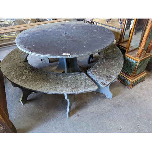 1112 - A heavy slate circular topped garden table, diameter 125cm, height 79cm together with four crescent ... 