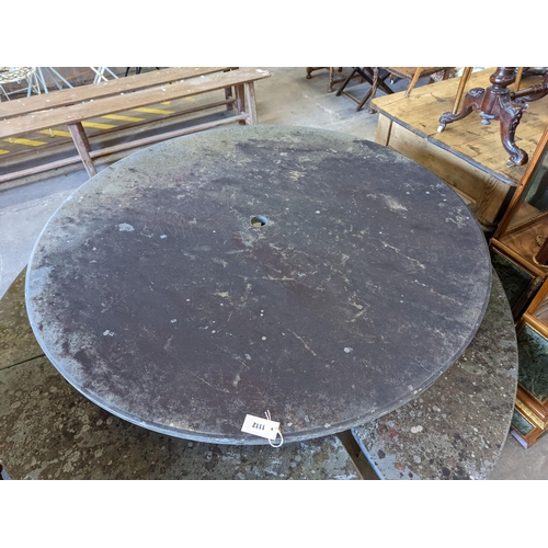 1112 - A heavy slate circular topped garden table, diameter 125cm, height 79cm together with four crescent ... 