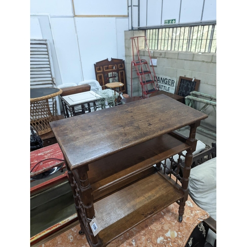 1135 - A late 19th century Continental oak three tier Liberty style table with slant top, width 70cm, depth... 