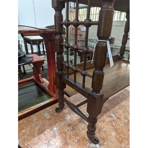 1135 - A late 19th century Continental oak three tier Liberty style table with slant top, width 70cm, depth... 