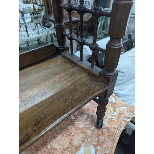 1135 - A late 19th century Continental oak three tier Liberty style table with slant top, width 70cm, depth... 