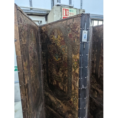 1138 - An embossed leather four fold dressing screen, each panel width 51cm, height 181cm