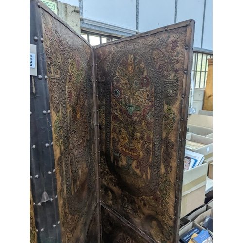 1138 - An embossed leather four fold dressing screen, each panel width 51cm, height 181cm