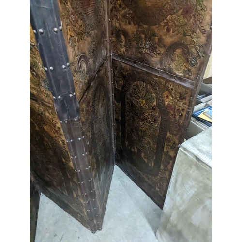 1138 - An embossed leather four fold dressing screen, each panel width 51cm, height 181cm