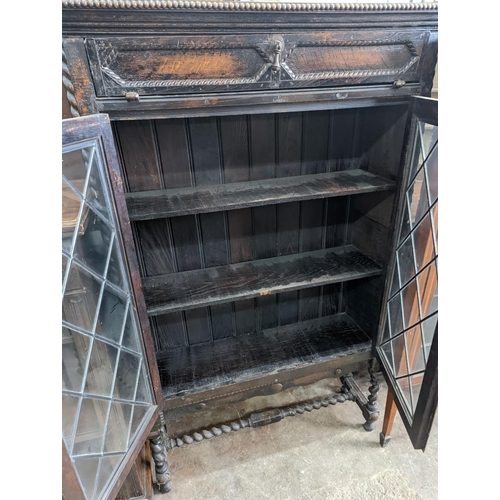 1149 - An early 20th century glazed oak two door bookcase, length 99cm, depth 29cm, height 150cm... 