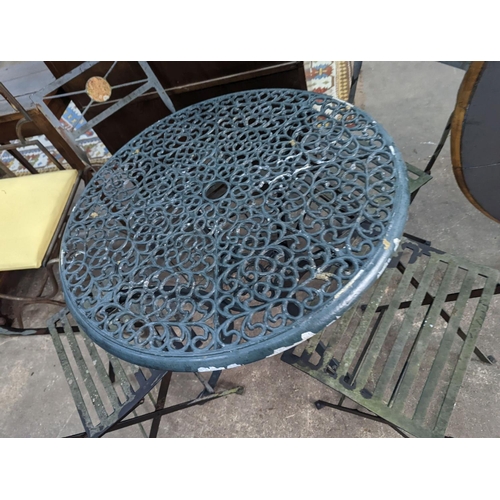 1157 - A circular aluminium garden table, diameter 74cm, height 72cm and four folding chairs