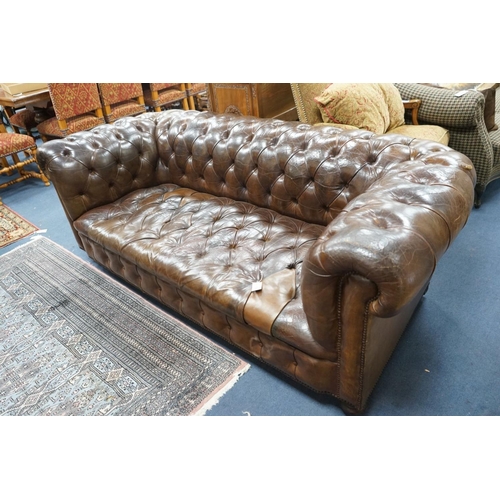 1193 - An early 20th century Chesterfield settee upholstered in deep buttoned brown leather, length 200cm, ... 