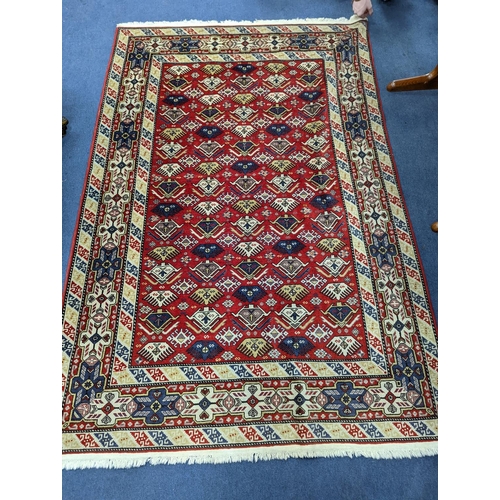 1195 - A Caucasian style red ground rug, 210 x 140cm