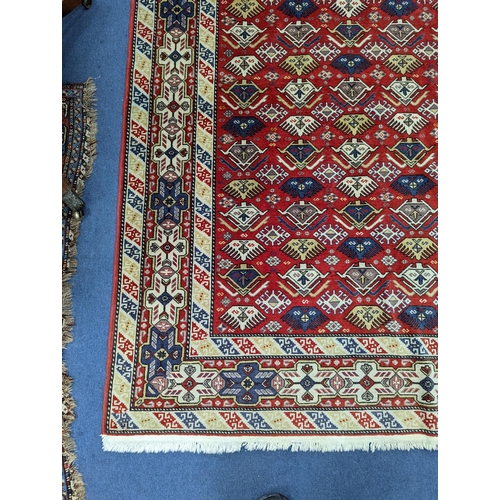 1195 - A Caucasian style red ground rug, 210 x 140cm