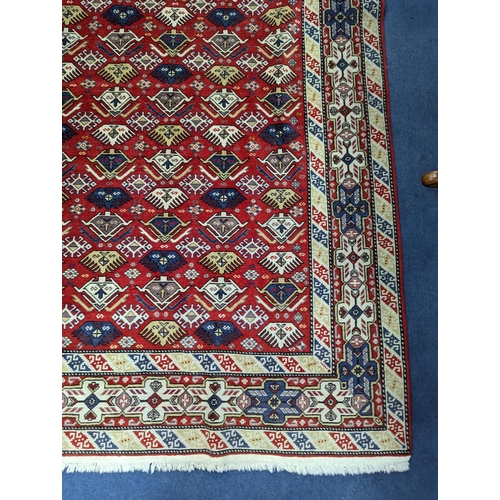 1195 - A Caucasian style red ground rug, 210 x 140cm