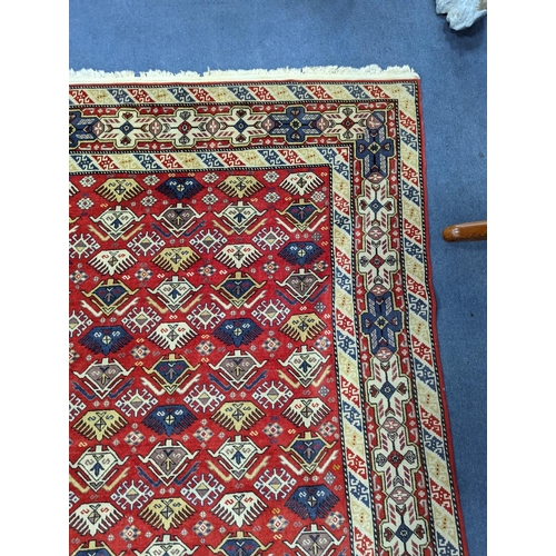 1195 - A Caucasian style red ground rug, 210 x 140cm