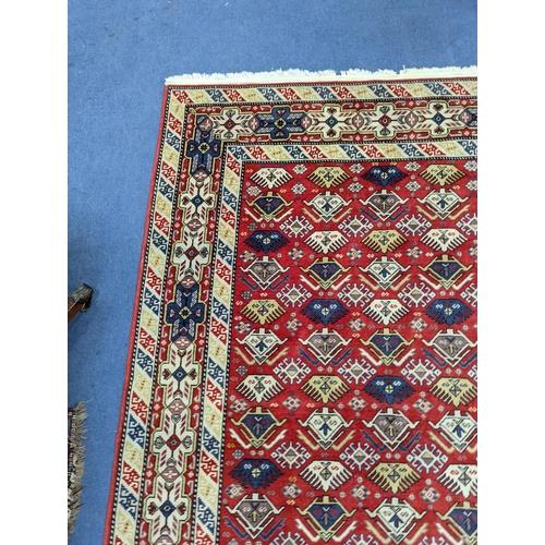 1195 - A Caucasian style red ground rug, 210 x 140cm