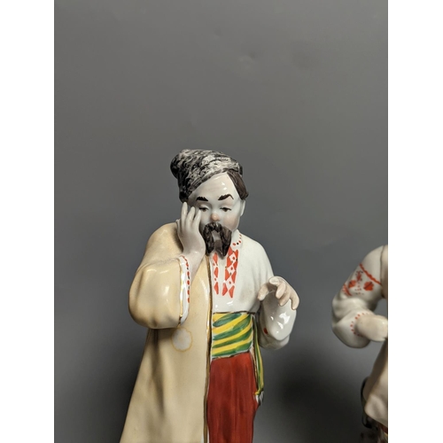 1261 - A pair of Russian porcelain figures of a Cossack and his wife 25cm