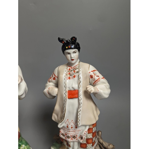 1261 - A pair of Russian porcelain figures of a Cossack and his wife 25cm