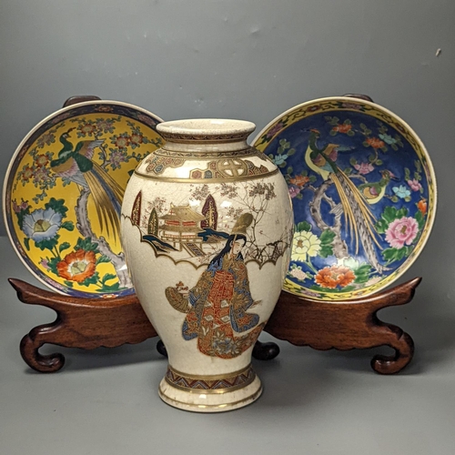 1371 - A Japanese Satsuma vase of a geisha and two Japanese yellow and a blue ground bowls each on wooden s... 