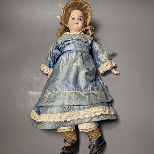 1378 - A German bisque headed doll, wearing a blue silk dress and straw bonnet, 42 cms high.