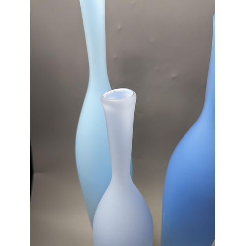 1379 - Three contemporary blue glass bottle vases,tallest 55cms high.