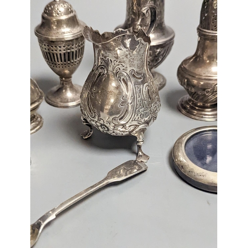 1837 - A Victorian embossed silver cream jug, London, 1883, 92mm, two 18th century silver pepperettes, one ... 