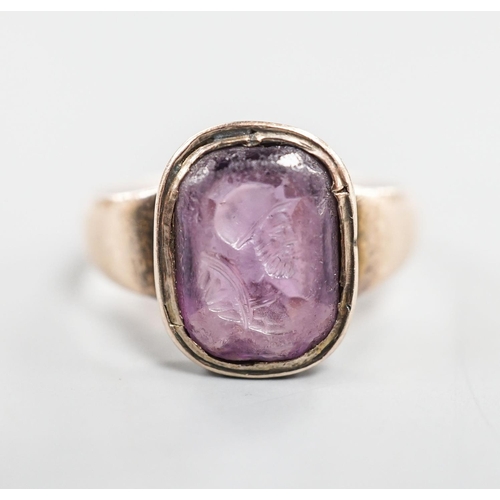 1881 - An antique intaglio amethyst paste, carved with the bust of a gentleman to sinister, mounted in a ye... 