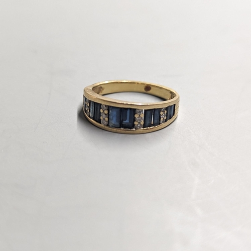 1949 - A modern yellow metal, diamond chip and graduated baguette cut sapphire set half hoop ring. size O, ... 