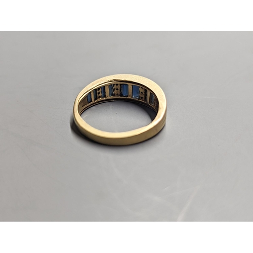 1949 - A modern yellow metal, diamond chip and graduated baguette cut sapphire set half hoop ring. size O, ... 