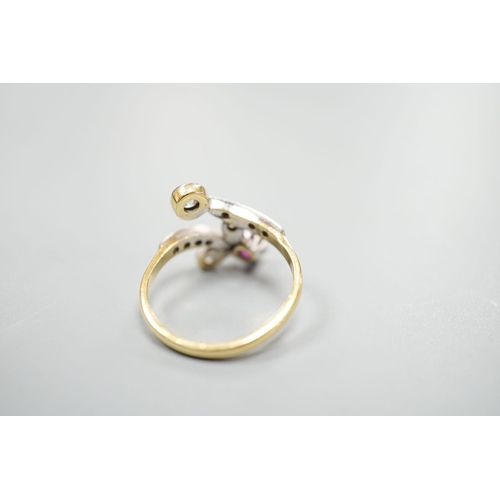 1950 - An early to mid 20th century 18ct, ruby and diamond set crossover ring, with diamond set shoulders, ... 