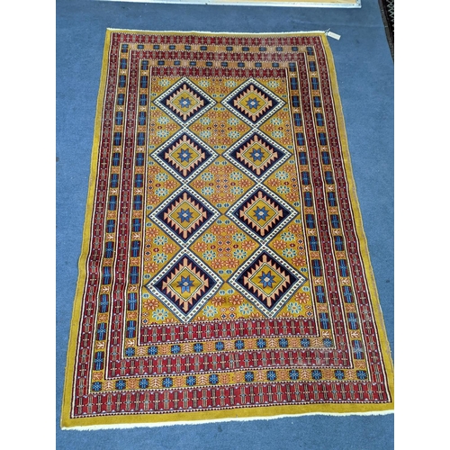 1084 - A Caucasian style gold ground rug, 190 x 124cm