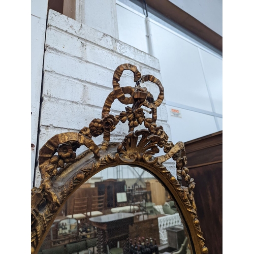 1006 - A late Victorian giltwood and gesso oval framed wall mirror, width 54cm, height 100cm