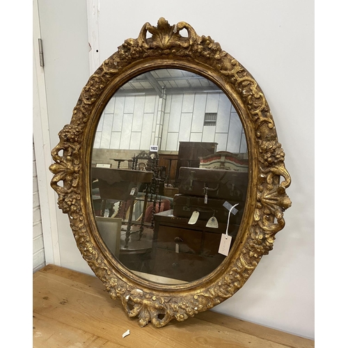 1022 - An oval giltwood and gesso wall mirror, width 89cm, height 108cm