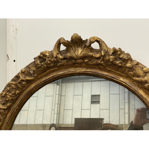 1022 - An oval giltwood and gesso wall mirror, width 89cm, height 108cm