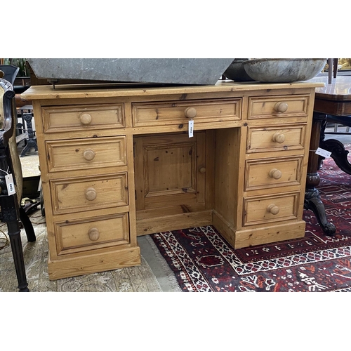 1052 - A Victorian style pine kneehole nine drawer desk with recessed cupboard, length 130cm, depth 50cm, h... 