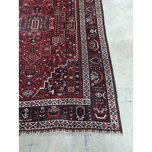 1057 - A Caucasian design burgundy ground carpet, 280 x 210cm