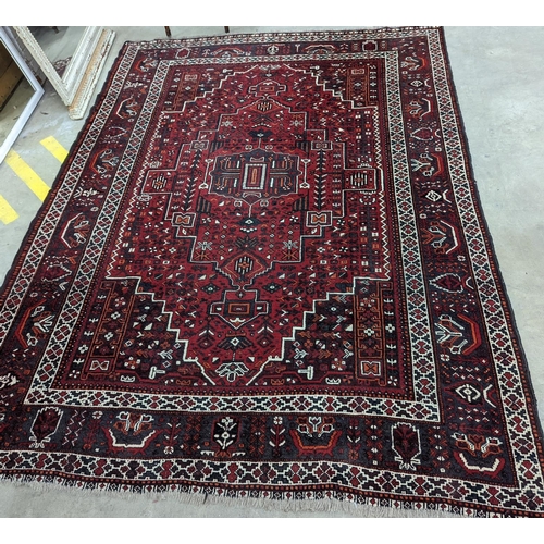 1057 - A Caucasian design burgundy ground carpet, 280 x 210cm