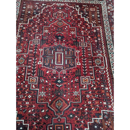 1057 - A Caucasian design burgundy ground carpet, 280 x 210cm