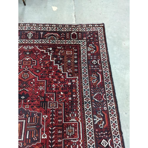 1057 - A Caucasian design burgundy ground carpet, 280 x 210cm