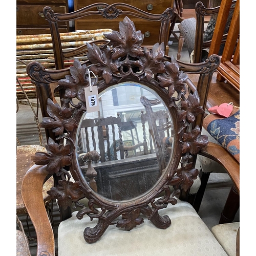 1076 - A 19th century oval Black Forest carved walnut wall mirror, width 54cm, height 66cm