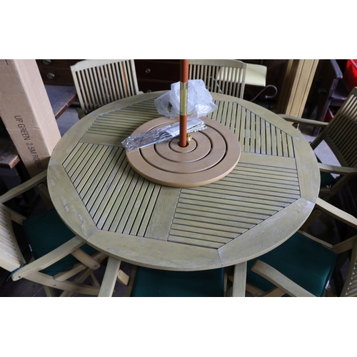 1120 - A teak garden set comprising circular table 148 cms diameter height 75 cms with 'Lazy Susan', paraso... 